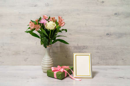 Colorful spring bouquet of rose, chrysanthemum and alstroemeria flowers in a vase with empty...