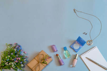 Fashion female accessories, flowers, cosmetics, perfume and jewelry on light blue pastel background. Feminine concept, greeting card for women's or mother's day. Flat lay, top view, copy space.の写真素材