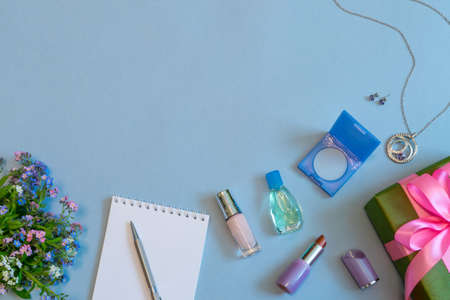 Fashion female accessories, flowers, cosmetics, perfume and jewelry on light blue pastel background. Feminine concept, greeting card for women's or mother's day. Flat lay, top view, copy space.の写真素材