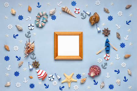 Round frame made of decorative items and miniature toys: seashells, seastars, vessel, boat, anchors, steering wheels, life buoys. Empty wooden photoframe, mock up. Summer vacation, sea travel conceptの写真素材