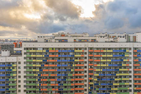 High-rise multi-storied residential buildings with loggias and windows against cloudy sky at sunset....