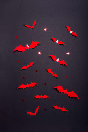 Halloween composition. Flock of red bats and spiders on black background. Happy halloween, trick or treat party concept. Flat lay, top view.の写真素材