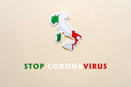Stop coronavirus in Italy. Map of Italy with italian flag on light paper background. Text STOP CORONAVIRUS. Covid-19 outbreak, pandemic concept.の写真素材