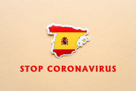 Stop coronavirus in Italy. Map of Spain with Spanish flag on light paper background. Text STOP CORONAVIRUS. Covid-19 outbreak, pandemic concept.の写真素材