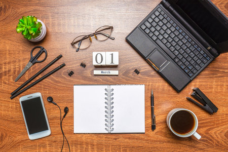 Modern office workplace with laptop keyboard, coffee cup, smart phone, stationery and plant. Date 01...