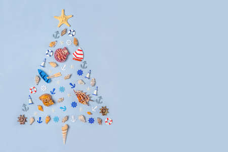 Christmas tree made of decorative ocean items: seashells, starfish, vessels, steering wheels, anchors. New year holidays at sea, travel, cruise, voyage concept. Copy space.の写真素材