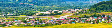 Panoramic view from hill to plain with small town in summer cloudy day. Picturesque urban landscape with many colorful houses. Sim, Chelyabinsk region, Russia. Travel blog concept.の写真素材