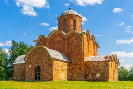 Church of Our Savior on Kovalev, Velikiy Novgorod vicinity, Russia. Russian landscape, green trees, grass and ancient orthodox temple against blue sky. Beautiful scenery and architectural landmark.の写真素材