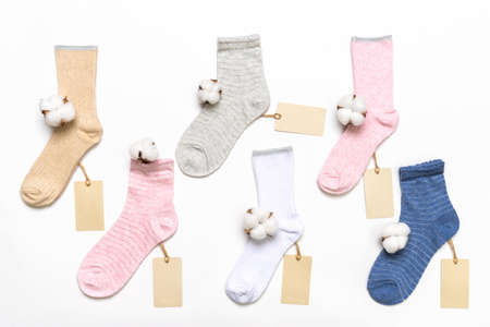 Various modern trendy women's cotton socks set with cotton flowers and price tags on white background. fashionable socks store. Socks shopping, sale, merchandise, advertisement concept.の写真素材