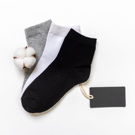 Various modern trendy women's cotton socks set with cotton flowers and price tags on white background. fashionable socks store. Socks shopping, sale, merchandise, advertisement concept.の写真素材