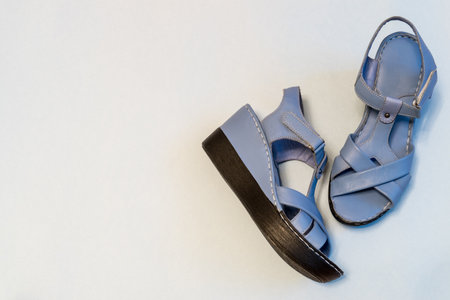 Blue sandals on light background. Stylish summer women's leather shoes, top view, copy space.の写真素材