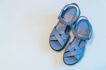 Blue sandals on light background. Stylish summer women's leather shoes, top view, copy space.の写真素材