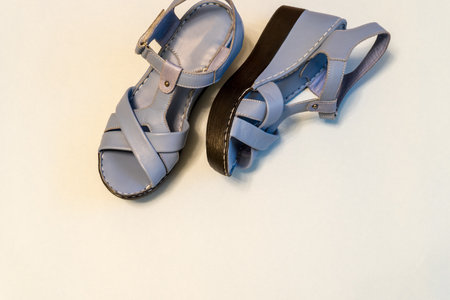 Blue sandals on light background. Stylish summer women's leather shoes, top view, copy space.の写真素材