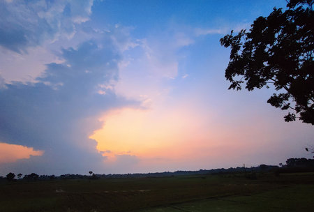 Sunset in the countryside of Thailand. The sky is blue and orange.の写真素材