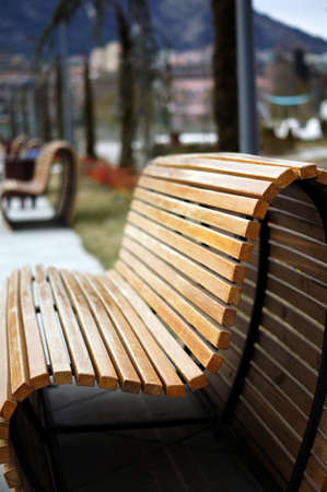 Wooden park bench in a sunny day - winter time