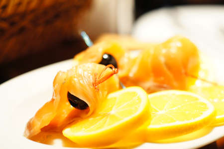 Salmon fish with pieces of lemon and olivesの写真素材