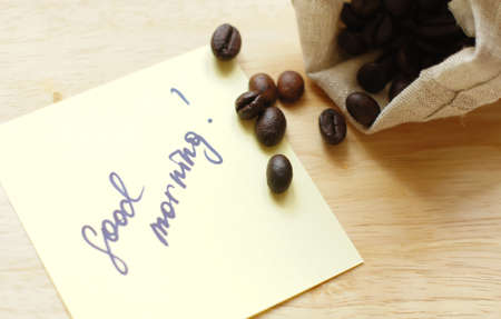 Coffee beans and Good morning note on the wooden desk