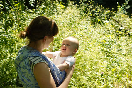 Nice woman with her baby boy in a sling baby carrierの写真素材