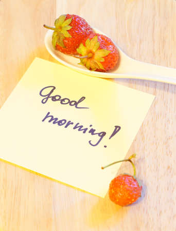 Small white china bowl filled with succulent juicy fresh ripe red strawberriesの写真素材