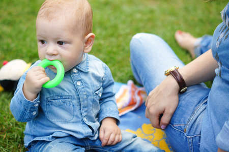 Little baby boy is plaing with his mother in the parkの写真素材