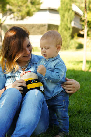 Little baby boy is plaing with his mother in the parkの写真素材