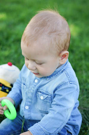 Baby boy is playning on the green grass