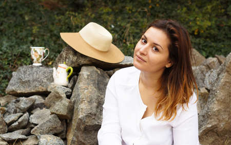 Portrait of beautiful young woman drinking tea outdoorの写真素材
