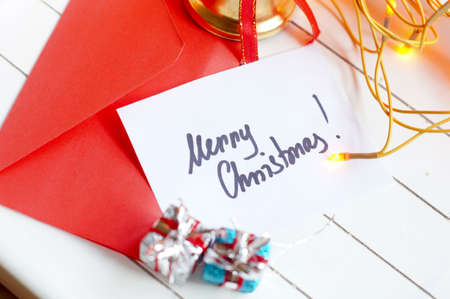 Merry Christmas note among holiday decorationの写真素材