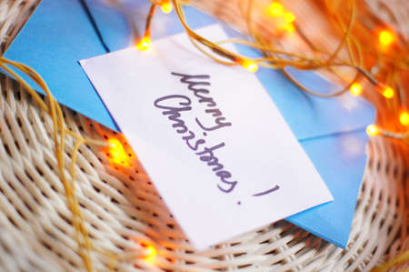 Merry Christmas note among holiday decorationの写真素材