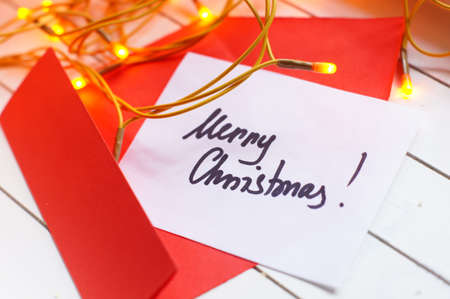 Merry Christmas note among holiday decorationの写真素材