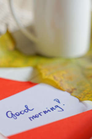 Autumn time: cup of tea, maple yellow leave and Good morning noteの写真素材