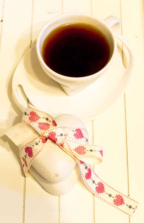 cup of hot coffee  decorated with heart-shaped cookies on the tableの写真素材