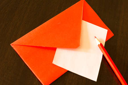 Red envelope with note, hearts and rose petalsの写真素材