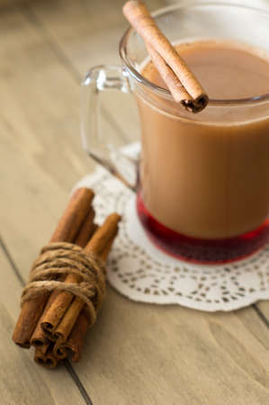 Glass of cacao, cookies and cinnamon on the wooden tableの写真素材