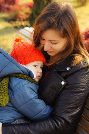 Beautiful mother and her son outdoor in the autumnal parkの写真素材