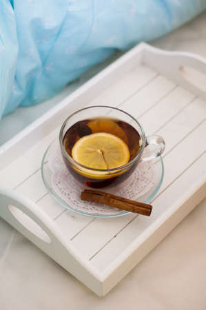 Cup of hip tea with lenom on the bed in the morning