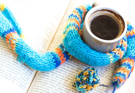 Cup of coffee, old book and notepad on the wooden table