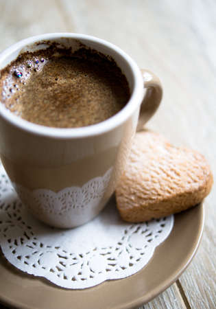 Cup of black coffee and cookie on the wooden tableの写真素材