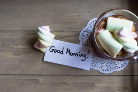 Cocoa drink and sweet paste zephyr in the glass on the wooden tableの写真素材