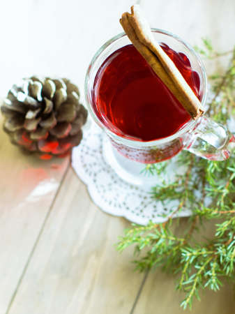 mulled wine with spices, sweets and orange on a wooden tableの写真素材