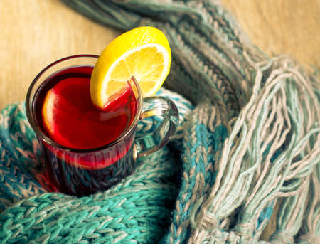 mulled wine with spices, sweets and orange on a wooden tableの写真素材