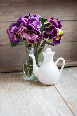 Glasses of green mint tea and vase with fresh violas on the tableの写真素材