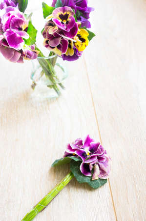 Viola flowers in a vase, old-styled clock and Good morning note on the tableの写真素材