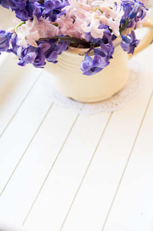 Hyacinth in an old clay vase with waterdrops and on a old piece of wood for a rustic look.の写真素材