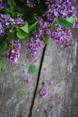 Lilac flowers in a vase on the old wooden tableの写真素材