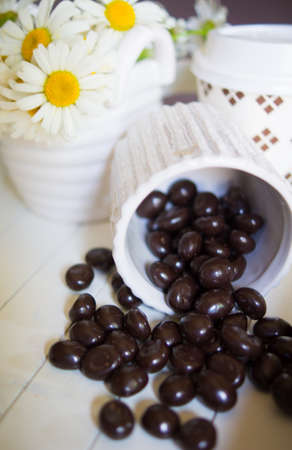 Daisy flowers and coffee beans on the tableの写真素材