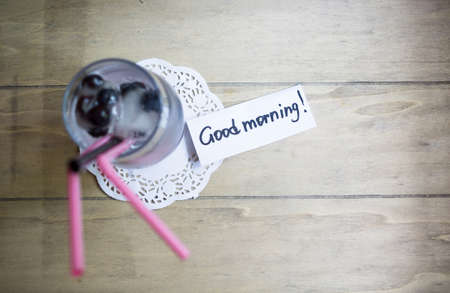 Blueberry juice / cocktail with ice and flowers on the wooden tableの写真素材