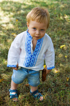 Little boy dressed in ukrainian embroidered costume outddor