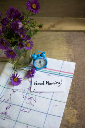 Cup of coffee and aster flowers in a vase on the wooden tableの写真素材