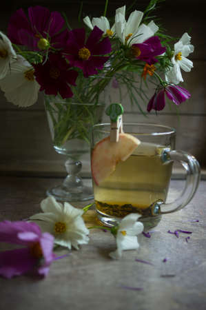 Coreopsis flowers in a vase and cup of green tea in the morningの写真素材